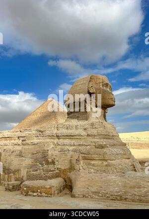 Die große Sphinx von Gizeh mit der berühmten Großen Pyramide im Hintergrund, ein zeitloser Blick auf die altägyptische Pracht. Stockfoto