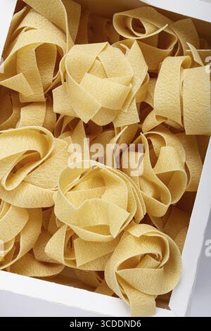 Rohe Pappardelle Nudeln, Nudelnester, in einem Papierkarton, Draufsicht, keine Leute Stockfoto