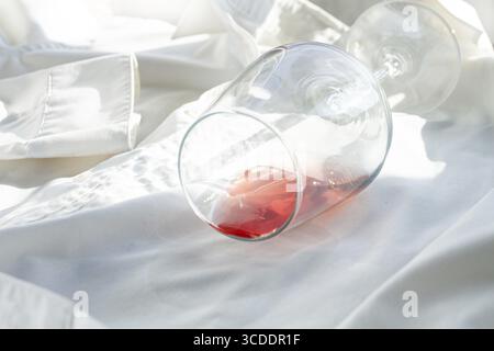 Glas, mit rosafarbenem Wein, verschüttet auf einem weißen Hemd, Nahaufnahme, selektiver Fokus, keine Leute, Konzept, Draufsicht Stockfoto