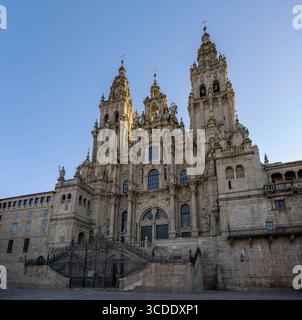Die kunstvolle Fassade der Kathedrale von Santiago de Compostela mit komplizierten Skulpturen und Türmen unter einem klaren blauen Himmel Stockfoto