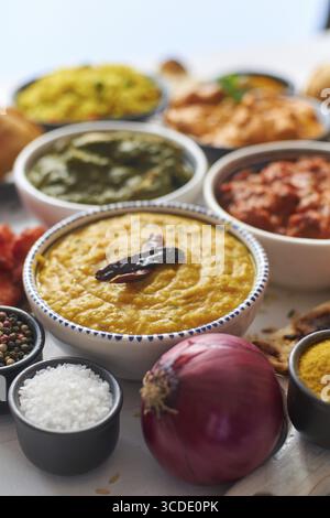 Traditionelle indische Küche in Keramikschalen. Verschiedene Gerichte serviert mit frischem Gemüse, Reis und Naanbrot. Flache Lagen Stockfoto