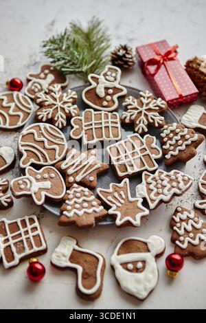 Verschiedene Formen von weihnachtlichen Lebkuchenkeksen, sortiert in Kreis und platziert aus weißem rostigem Tisch. Mit Kopierraum. Draufsicht Stockfoto