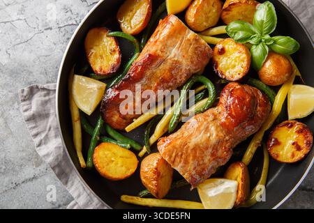 Gebackenes Zitronenknoblauch Schweinefilet mit französischen Bohnen und neuen Kartoffeln in einer Pfanne auf dem Tisch. Horizontale Draufsicht von oben Stockfoto