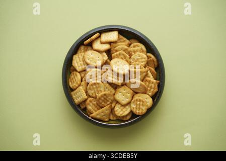 Draufsicht der Schüssel mit salzigen Crackern auf olivem Hintergrund Stockfoto