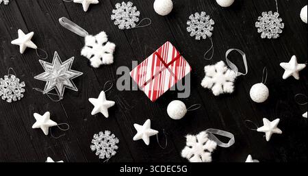 Von oben Blick auf die weissen Weihnachten Dekorationen mit wenig verpackte Geschenk in der Mitte auf Holz- Hintergrund gelegt Stockfoto