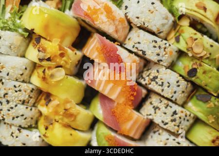 Verschiedene traditionelle Sushi-Brötchen Hintergrund. Köstliches japanisches Essen. Draufsicht, flach Stockfoto