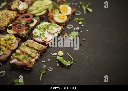 Blick von oben auf die verschiedenen dekorierten Sandwiches als Vorspeise. Gesunde Ernährung. Gemüsemahlkonzept Stockfoto