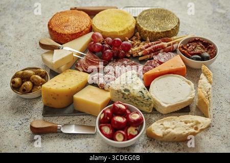 Köstliche Mischung aus verschiedenen Snacks und Vorspeisen. Spanische Tapas oder italienische Antipasti auf einem schwarzen Steinteller. Blick von oben. Auf Steintisch Stockfoto
