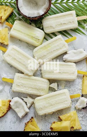 Hausgemachte vegane Stierkel mit Kokosmilch und Ananas. Köstlicher gesunder Sommer-Snack. Draufsicht, flach Stockfoto