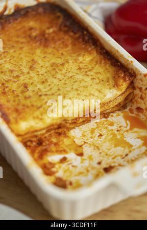 Traditionelles italienisches leckeres Gericht. Fleischlasagne mit Tomatensauce und geschmolzenem Käse in weißer Auflaufform Stockfoto