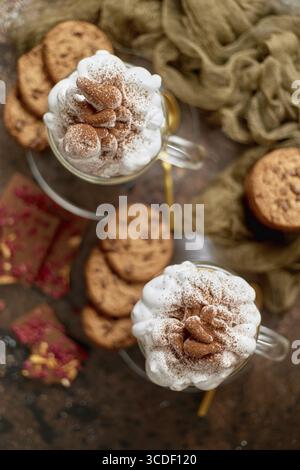 Süßes Dessert serviert. Heiße Schokolade mit Schlagsahne und Keksen. Draufsicht, flach Stockfoto
