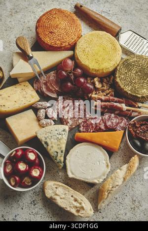 Köstliche Mischung aus verschiedenen Snacks und Vorspeisen. Spanische Tapas oder italienische Antipasti auf einem schwarzen Steinteller. Blick von oben. Auf Steintisch Stockfoto
