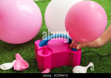 Frau, die einen Ballon mit Luftpumpe im Haus aufbläst, Nahaufnahme Stockfoto
