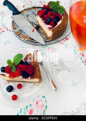 New Yorker Käsekuchen mit Beeren, dekoriert mit frischer Minze, auf einem Tisch. Hausgemachte Desserts. Stockfoto
