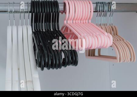 Verschiedene Sets von Kleiderbügeln in Kleiderschränken in verschiedenen Formen, Materialien und Farben Stockfoto