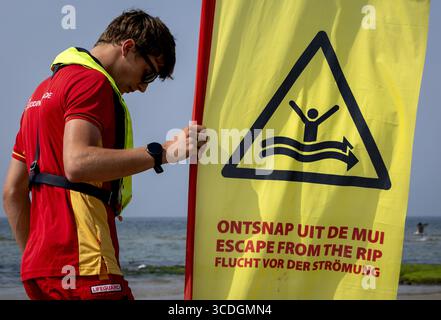 CALLANTSOOG – Eine Rettungsfahne warnt Schwimmer vor einem Stromschlag. Ein Rip Current ist ein Kanal senkrecht zum Strand, durch den Wasser heftig ins Meer fließt. Jeder, der darin gefangen ist, kann nicht dagegen schwimmen. ANP KOEN VAN WEEL niederlande aus - belgien aus Stockfoto