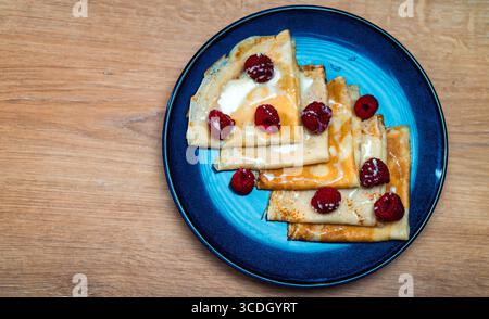 Pfannkuchen mit Himbeeren und Kondensmilch. Stockfoto