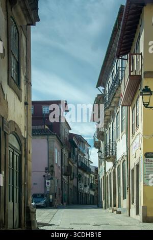 Chaves, Portugal: 13. August 2023: Eine vertikale Perspektive in einer sehr engen, schattigen Gasse im historischen Zentrum von chaves, portugal Stockfoto