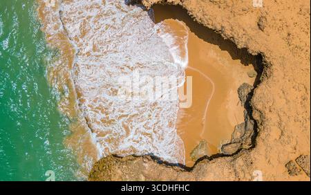Atemberaubendes Luftbild von Cabo de la Vela, das das türkisfarbene Meer auf goldenen Sand in La Guajira, Kolumbien, zeigt. Stockfoto