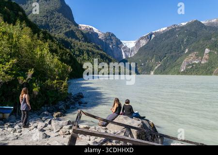 Touristen genießen den Blick auf das türkisfarbene Wasser und den hängenden Gletscher im queulat-Nationalpark, Aysen, chile, patagonien Stockfoto
