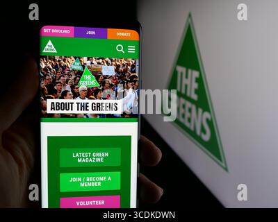 Stuttgart, Deutschland - 08.01.2025: Person, die ein Handy hält, mit Webseite der australischen Grünen auf dem Bildschirm vor dem Logo. Stockfoto