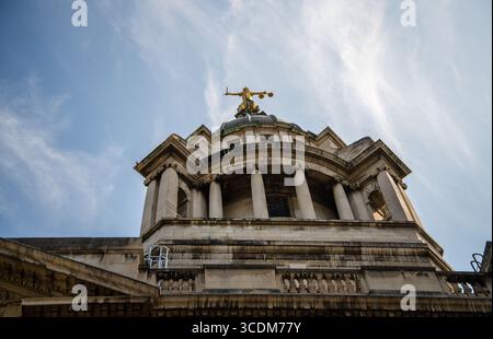 Blick auf die goldene Statue von Lady Justice auf dem Central Criminal Court in London, vor einem hellblauen Sommerhimmel. Stockfoto