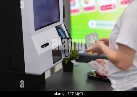 Eine Frau scannt Artikel an einer Selbstkasse. Stockfoto