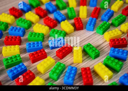 Bunte Kunststoffbausteine, die kreisförmig auf einer Holzfläche angeordnet sind. Stockfoto