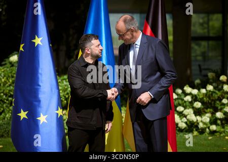 Berlin, Deutschland. August 2025. Der ukrainische Präsident Wolodymyr Zelenskyj, links, schüttelt bei der Ankunft im Bundeskanzleramt am 13. August 2025 in Berlin die Hand mit dem deutschen Bundeskanzler Friedrich Merz. Zelenskyy besucht ein virtuelles Gipfeltreffen mit europäischen Staats- und Regierungschefs und US-Präsident Donald Trump. Quelle: Pool Photo/Ukrainische Präsidentenpresse/Alamy Live News Stockfoto
