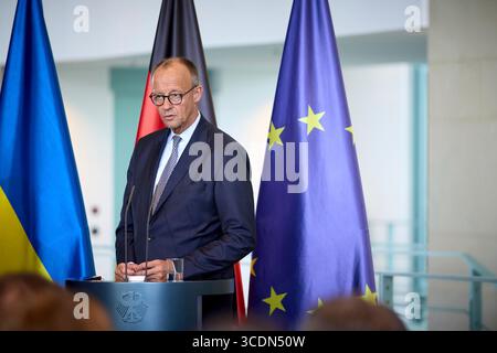 Berlin, Deutschland. August 2025. Bundeskanzler Friedrich Merz hört eine Frage während einer gemeinsamen Pressekonferenz mit dem ukrainischen Präsidenten Wolodymyr Zelenskyj im Kanzleramt am 13. August 2025 in Berlin. Das Briefing folgte auf ein virtuelles Gipfeltreffen mit europäischen Staats- und Regierungschefs und US-Präsident Donald Trump. Quelle: Pool Photo/Ukrainische Präsidentenpresse/Alamy Live News Stockfoto