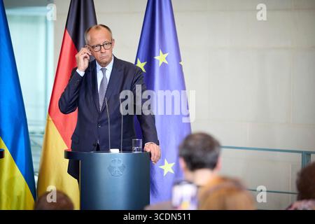 Berlin, Deutschland. August 2025. Bundeskanzler Friedrich Merz hört eine Frage während einer gemeinsamen Pressekonferenz mit dem ukrainischen Präsidenten Wolodymyr Zelenskyj im Kanzleramt am 13. August 2025 in Berlin. Das Briefing folgte auf ein virtuelles Gipfeltreffen mit europäischen Staats- und Regierungschefs und US-Präsident Donald Trump. Quelle: Pool Photo/Ukrainische Präsidentenpresse/Alamy Live News Stockfoto