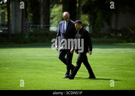 Berlin, Deutschland. August 2025. Der ukrainische Präsident Wolodymyr Zelenskyj, rechts, wird von Bundeskanzler Friedrich Merz, links, bei der Ankunft mit dem Hubschrauber zum Bundeskanzleramt am 13. August 2025 in Berlin begleitet. Zelenskyy besucht ein virtuelles Gipfeltreffen mit europäischen Staats- und Regierungschefs und US-Präsident Donald Trump. Quelle: Pool Photo/Ukrainische Präsidentenpresse/Alamy Live News Stockfoto