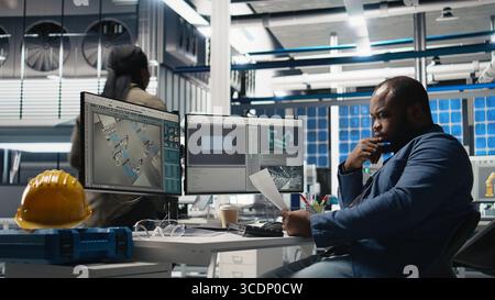 afroamerikanischer Wirtschaftsingenieur, der den Betrieb der Solarzellen überprüft und den Herstellungsprozess für die Photovoltaik-Industrie bearbeitet. Experte in modernen Anlagen. Kamera A.. Stockfoto