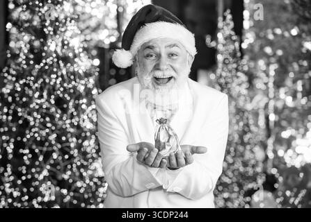 Weihnachten ist Zeit zum Geben. elite teures Neujahrsgeschenk für Männer. Männliches Zubehör. Kleines und angenehmes Souvenir. Glücklicher Mann mit Goldsackgeschenk Stockfoto