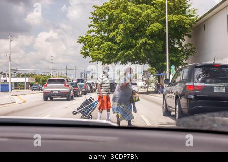 Miami Florida, NE 79th Street, Schwarzes Seniorenpaar, Frau, die jaywalk, die Straße überquert, dem Verkehr ausweichen, Blick durch die Windschutzscheibe, die Straße i überquert Stockfoto