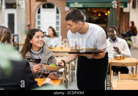 Der Kellner brachte eine fertige Bestellung in ein Restaurant Stockfoto