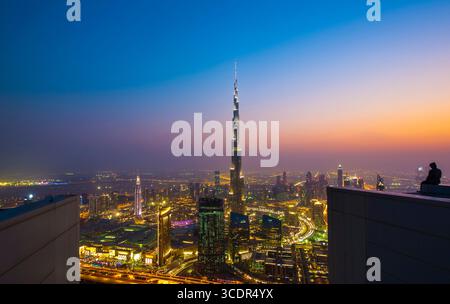 Atemberaubende Skyline der Stadt Dubai bei Sonnenuntergang mit beleuchteten Wolkenkratzern, Burj Khalifa Tower, moderner Architektur, lebendigen Lichtern, luxuriösem Reiseziel Stockfoto