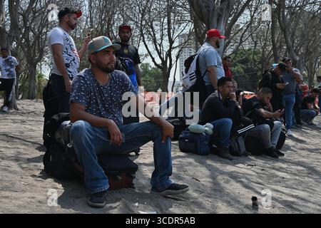 Tijuana, Baja California, Mexiko. August 2025. Mexikanische Arbeiter mit Arbeitsvisum stehen am Mittwoch, den 13. August 2025, in der Nähe des San Ysidro Port of Entry an der US-mexikanischen Grenze in Tijuana, Mexiko, an. Nach den EISATTACKEN in den USA gibt es einen bemerkenswerten Mangel an Tagarbeitern, insbesondere in Branchen, die auf Arbeiter ohne Papiere angewiesen sind, wie etwa Feldarbeiter in der Landwirtschaft. Die meisten mexikanischen Arbeiter, die auf die Überquerung nach San Diego, Kalifornien, warteten, fahren in den US-Bundesstaat Washington, um in den üppigen Apfelplantagen des Bundesstaates zu arbeiten. (Kreditbild: © Carlos A. Moreno/ZUMA Press Stockfoto
