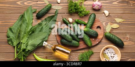 Zusammensetzung mit frischen Gurken und Zutaten zur Konservierung auf hölzernem Hintergrund Stockfoto