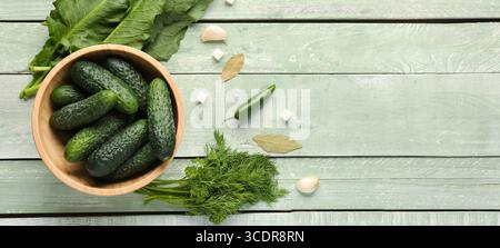 Komposition mit frischen Gurken und Zutaten zur Konservierung auf grünem Holzhintergrund mit Platz für Text Stockfoto