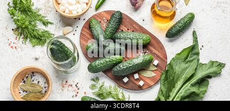 Zusammensetzung mit frischen Gurken und Zutaten zur Konservierung auf weißem Holzhintergrund Stockfoto