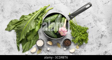 Zusammensetzung mit frischen Gurken und Zutaten zur Konservierung auf Grunge-Hintergrund Stockfoto