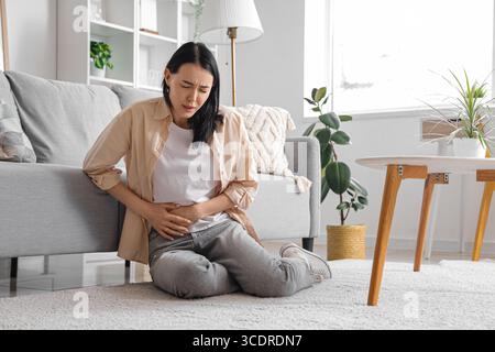 Junge Frau mit starken Bauchschmerzen zu Hause Stockfoto