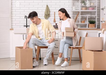 Das junge Paar packt Paketboxen in der Küche aus Stockfoto