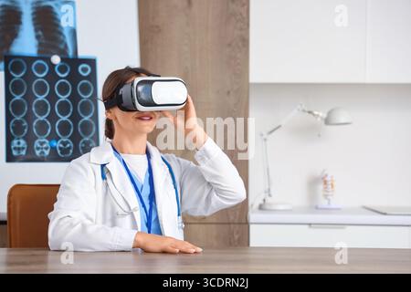 Ärztin mit VR-Brille am Tisch in der Klinik Stockfoto