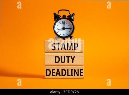 Symbol für die Fälligkeitsfrist für Stempelabgabe. Concept Words Stamp Duty Deadline auf Holzblöcken. Schöner oranger Hintergrund mit Wecker. Geschäft und Stempel - Aufgabe Stockfoto