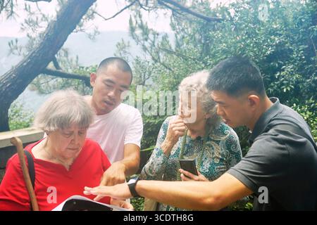 (250814) -- PEKING/FUZHOU, 14. August 2025 (Xinhua) -- Elyn MacInnis (1. L) liest eine alte Karte von Kuliang, heute ein Ferienort am Hang, in Fuzhou, südöstlicher chinesischer Provinz Fujian, 24. Juni 2023. (Xinhua) Stockfoto