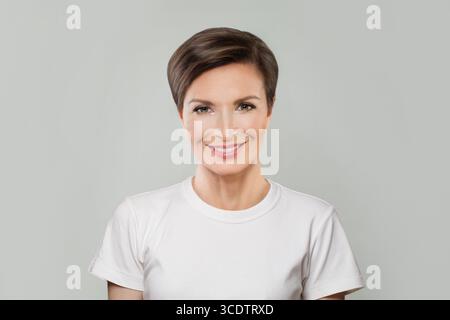 Erfolgreiche reife Frau im mittleren Alter, die in die Kamera blickt und lächelt. Gesunde Gesichtspflege Schönheit, Mittelalter Hautpflegekosmetik und Kosmetikkonzept Stockfoto