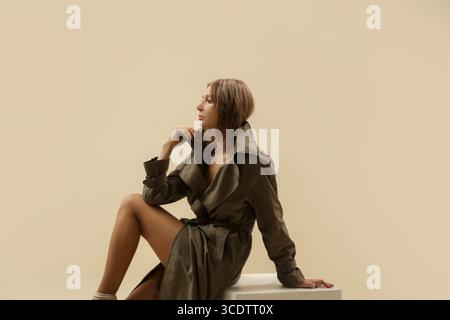 Serie von Studiofotos von Frau im klassischen grünen Trenchcoat, klassischer Herbstmodeartikel. Stockfoto