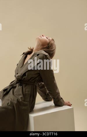 Serie von Studiofotos von Frau im klassischen grünen Trenchcoat, klassischer Herbstmodeartikel. Stockfoto